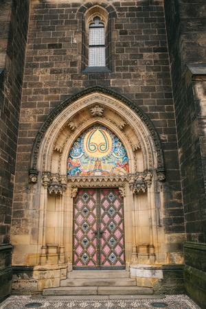 A beautiful antique door to the Catholic cathedral located in the High City called Vysehrad in Prague. Entrance to the cathedral.の写真素材