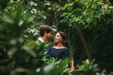 A loving young beautiful couple of students from Europe hugging between trees in a park. Close feelings and emotions between people.の写真素材