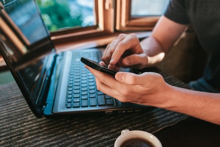 A young man-blogger freelancer working on a laptop in a cafe in Istanbul and calling by phone. View...