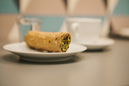 Italian sweet traditional food Cannoli. Fresh pastry with pistachio filling inside