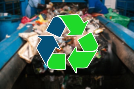 Sign recycling waste. The waste sorting and processing plant is blurry in the backgroundの写真素材