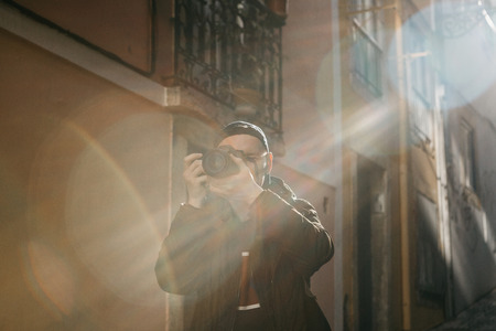 A street photographer or a young man takes pictures of authentic houses in Lisbon in Portugal. A...