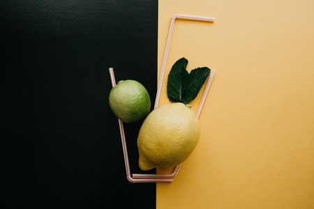 Conceptual photography. Citrus lemonade or juice from fresh fruits in a glass of tubules