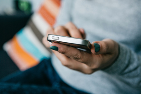 A girl uses a cell phone to call or send a message or to communicate in a social network or uses the application. Close-upの写真素材