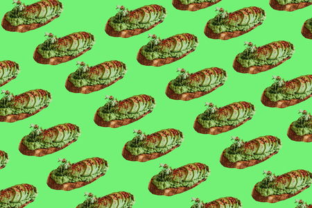 Background of a lot of delicious and nutritious veggie toasts or sandwiches with avocado and guacamole in a minimal styleの写真素材