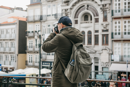 A professional travel photographer or tourist photographs a beautiful cityscape in Porto in Portugal. Professional occupation or hobbyの写真素材