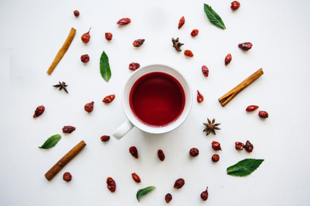 A cup of fragrant and tasty red or herbal tea on a white surface decorated in a Christmas styleの写真素材