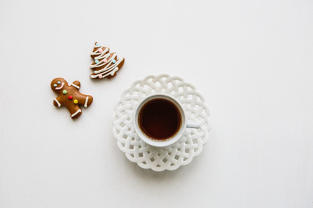 A cup of fragrant and tasty herbal or black tea on a white surface. Nearby lie Christmas gingerbread or cookies.の写真素材