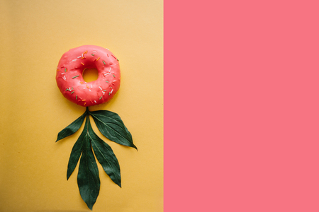 Donut on a colored background. Nearby lie the leaves for decoration.の写真素材