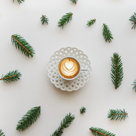 A cup of fresh fragrant cappuccino coffee next to the fir branches in the Christmas or New Years style. Christmas concept.の写真素材
