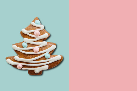 A traditional Christmas gingerbread cookie in the form of a Christmas tree on a colored background.の写真素材