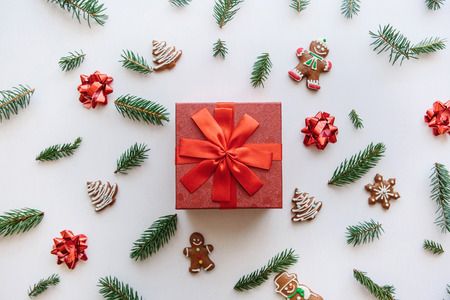 Christmas or New Year gift in a red box. Nearby are various holiday things including ginger biscuits. Christmas concept.の写真素材