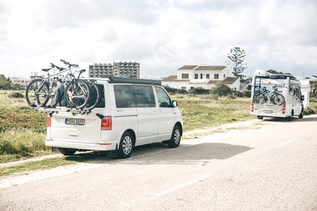 Portugal, Lagos, 12 April 2018: Cars for travel with bicycles parked at the side of the road. Active rest and family travel.のeditorial素材