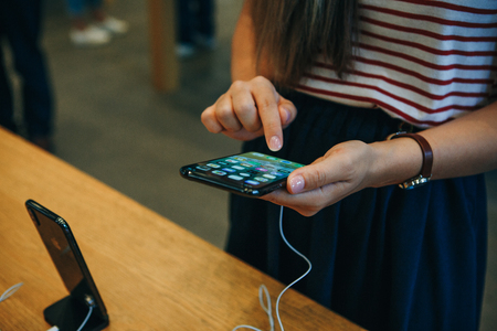 Berlin, August 29, 2018: The buyer looks to buy a new modern iPhone X in the official Apple store in Berlin in Germany.のeditorial素材