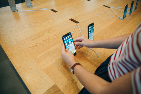 Berlin, August 29, 2018: The buyer looks to buy a new modern iPhone X or takes the phone in hand at the official Apple store in Berlin in Germany.のeditorial素材
