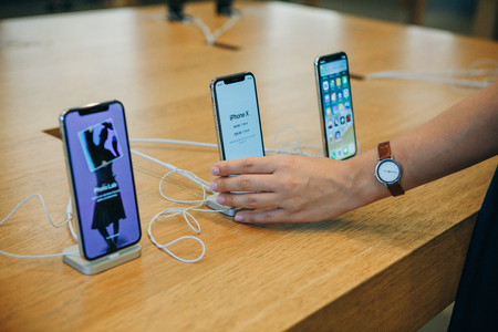 Berlin, August 29, 2018: The buyer looks to buy a new modern iPhone X or takes the phone in hand at the official Apple store in Berlin in Germany.のeditorial素材