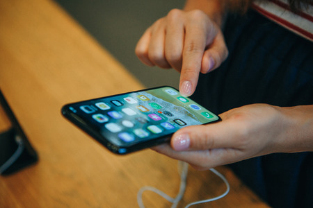 Berlin, August 29, 2018: The buyer looks to buy a new modern iPhone X in the official Apple store in Berlin in Germany.のeditorial素材