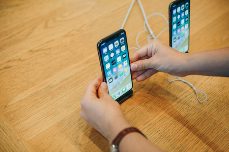 Berlin, August 29, 2018: The buyer looks to buy a new modern iPhone X or takes the phone in hand at the official Apple store in Berlin in Germany.のeditorial素材