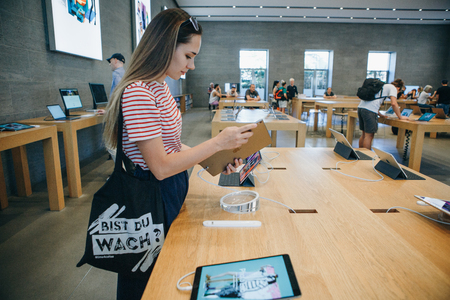 Berlin, August 29, 2018: The buyer chooses to buy a new iPad in the official store of Apple in Berlin.のeditorial素材
