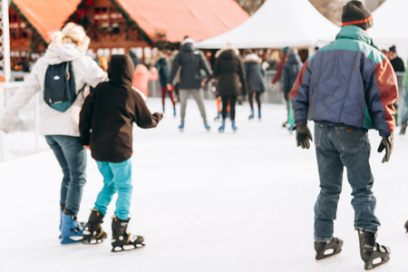 Blurred background people ride on an open skating rink on Alexanderplatz in Berlin in Germany during the Christmas holidays.の写真素材