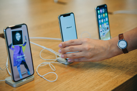 Berlin, August 29, 2018: The buyer looks to buy a new modern iPhone X or takes the phone in hand at the official Apple store in Berlin in Germany.のeditorial素材