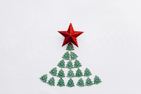 Creative idea in minimalistic style for Christmas or New Year themes. Christmas tree from other small wooden Christmas trees and a star on top. Celebratory concept.の写真素材