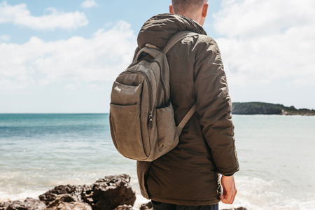 A tourist or traveler with a backpack on the Atlantic coast in Portugal.の写真素材