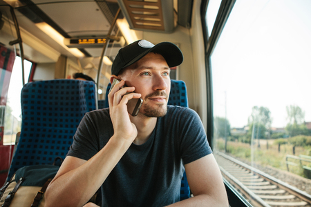 A person or a tourist rides a train and talks on the phone.の写真素材
