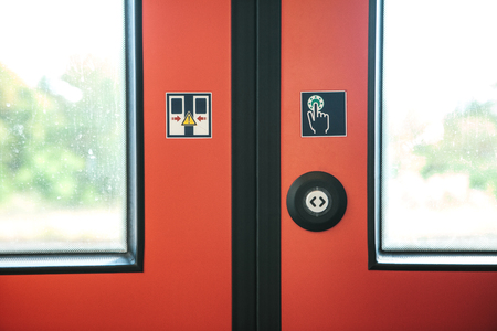 Close-up. The exit door of the train with a button to automatically open the door on demand when the train stops.の写真素材
