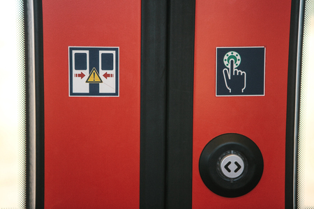 Close-up. The exit door of the train with a button to automatically open the door on demand when the train stops.の写真素材