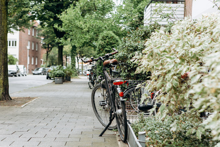 The bike is parked near the house on a beautiful street. Eco-friendly and popular transport in small cities.の写真素材