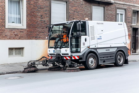 Germany, Muenster, October 5, 2018: A special truck or street cleaning vehicle rides along the road and cleans the street from dirt and dust.のeditorial素材