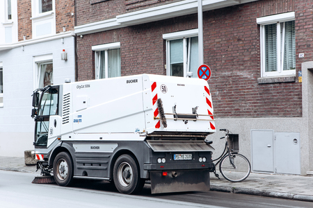 Germany, Muenster, October 5, 2018: A special truck or street cleaning vehicle rides along the road and cleans the street from dirt and dust.のeditorial素材