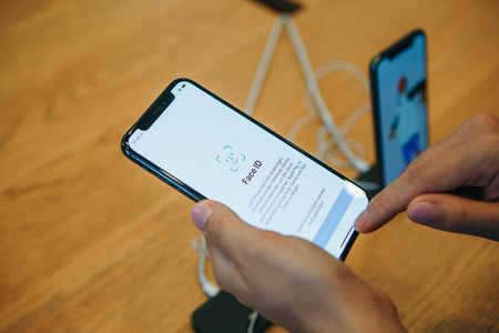 Berlin, August 29, 2018: The buyer looks to buy a new modern iPhone X with face detection technology or an face ID in the official Apple store in Berlin in Germany.のeditorial素材