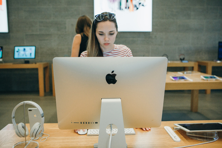Berlin, August 29, 2018: The buyer is looking for a new IMac for purchase in the official Apple Store in Berlin. Choosing a computer for yourself or as a gift.のeditorial素材