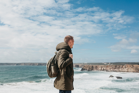 A tourist or traveler with a backpack on the Atlantic coast in Portugal.の写真素材