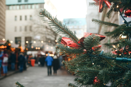 Christmas tree or fir branches in the foreground. The Christmas market in Germany is blurred in the background. Vacation. People relax during the holidays.の写真素材