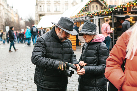 Prague, December 25, 2017: An elderly couple is looking at a map on the main square while traveling around Prague during the Christmas holidays.のeditorial素材
