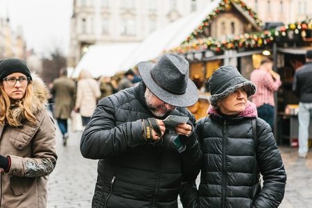 Prague, December 25, 2017: An elderly couple is looking at a map on the main square while traveling around Prague during the Christmas holidays.のeditorial素材