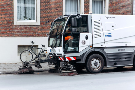 Germany, Muenster, October 5, 2018: A special truck or street cleaning vehicle rides along the road and cleans the street from dirt and dust.のeditorial素材