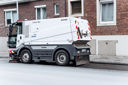 Germany, Muenster, October 5, 2018: A special truck or street cleaning vehicle rides along the road and cleans the street from dirt and dust.のeditorial素材