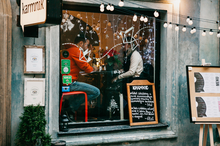 Warsaw, December 31, 2017: Cafe decorated in Christmas style. People or a couple are sitting and chatting with each other at a table near the window.のeditorial素材
