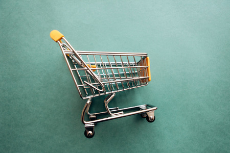 Empty cart for products and goods on a green background.の写真素材