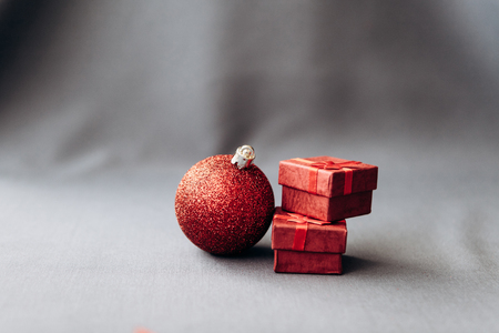 Small boxes with Christmas gifts and a red ball on a dark background. Christmas celebration concept.の写真素材