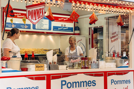 Germany, Muenster, October 5 2018: Street tent selling french fries. The inscription in German is translated Holland fries. Small business at the city fair.のeditorial素材