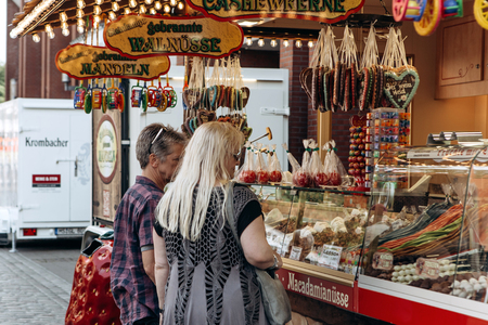 Germany, Muenster, October 5 2018: Street tent for the sale of sweets. The inscription in German translates fried chocolate fruit. Small business at the city fair.のeditorial素材
