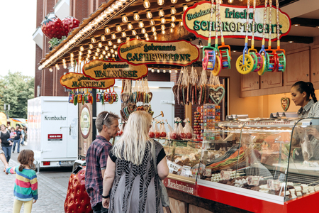 Germany, Muenster, October 5 2018: Street tent for the sale of sweets. The inscription in German translates fried chocolate fruit. Small business at the city fair.のeditorial素材