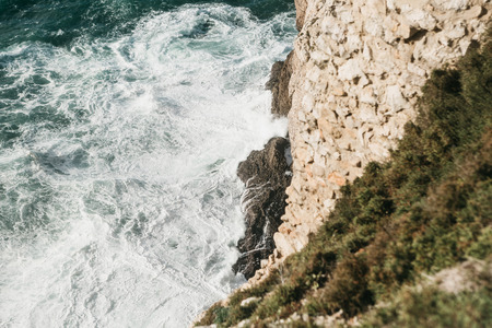 Top view of the waves and beautiful blue water with white foam of the Atlantic Ocean on the rocky...