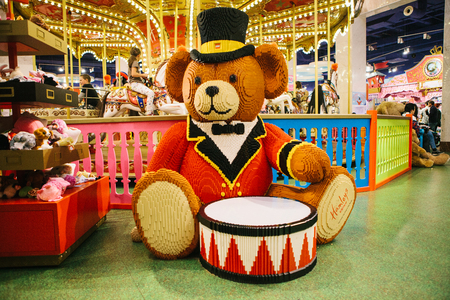 Prague September 29, 2018: A huge bear with a drum made from Lego in a toy store Hamleys. In the background is a carousel.のeditorial素材
