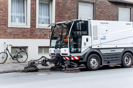 Germany, Muenster, October 5, 2018: A special truck or street cleaning vehicle rides along the road and cleans the street from dirt and dust.のeditorial素材